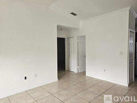 A room with a tiled floor and a doorway leading to another room.
