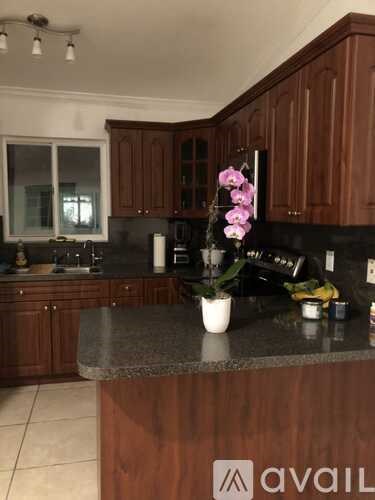 A kitchen with wooden cabinets and a granite countertop.
