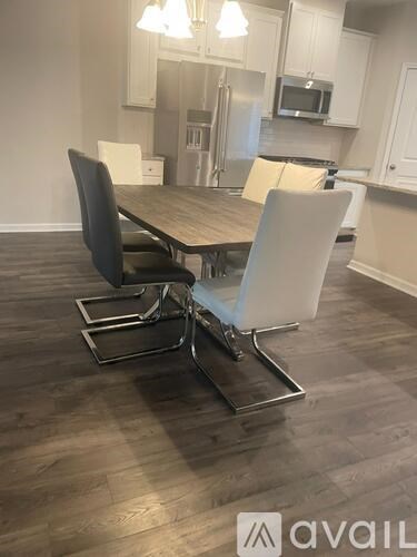 A dining room with a table and chairs.