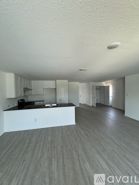 A spacious kitchen with white cabinets and a black countertop.
