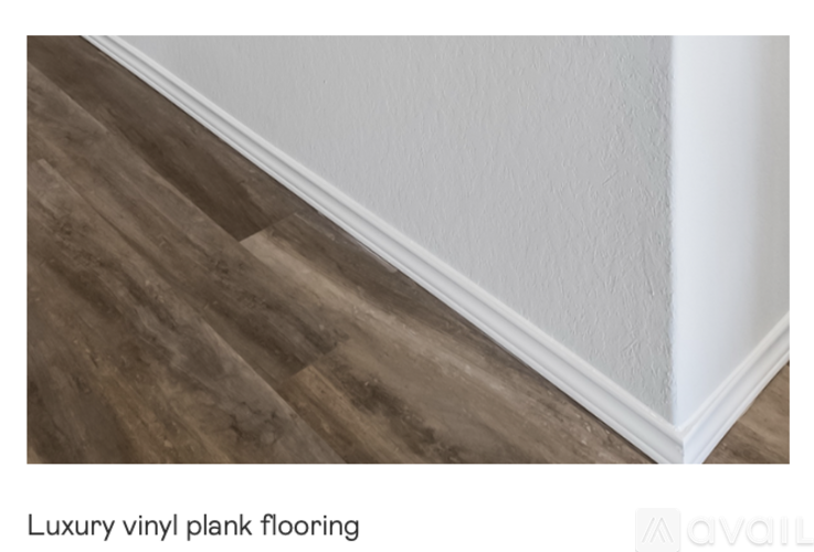 A close up of a wooden floor with the text "Luxury vinyl plank flooring" below it.