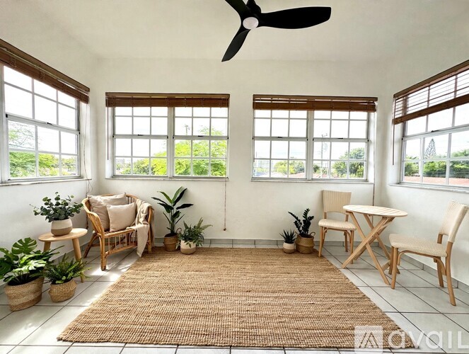A living room with a fan, two chairs, and a table.