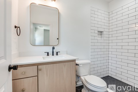 A bathroom with a white toilet, sink, and mirror.