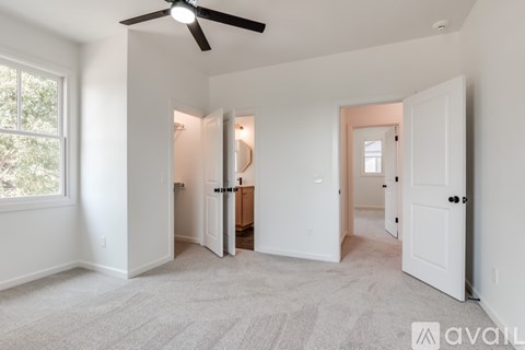 A room with a ceiling fan and carpeted floor.