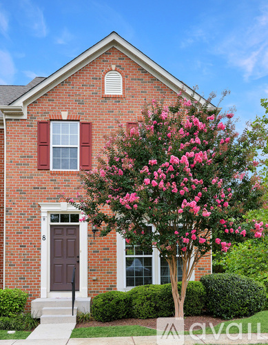 A brick house with a tree in front of it.