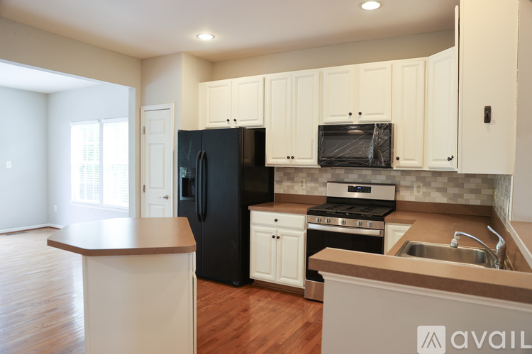 A kitchen with black appliances and white cabinets.