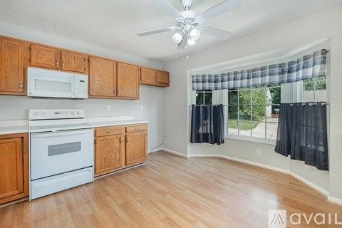 A kitchen with wooden cabinets and a white stove top oven.