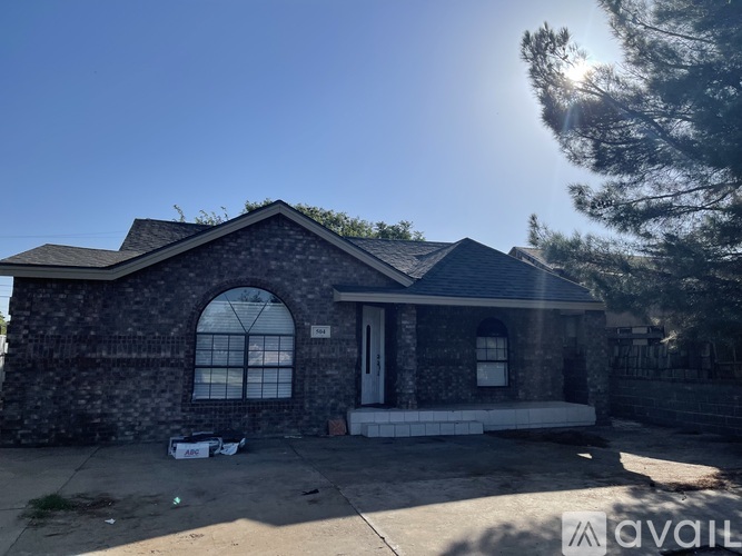 A house with a stone facade and a large arched window is for sale.