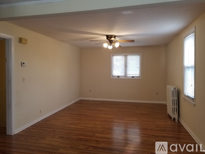 A room with wooden floors and a ceiling fan.