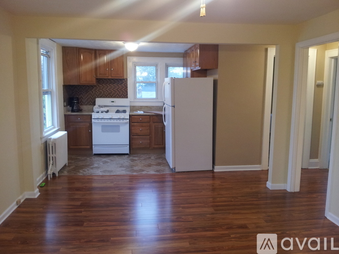 A kitchen with white appliances and wooden cabinets.