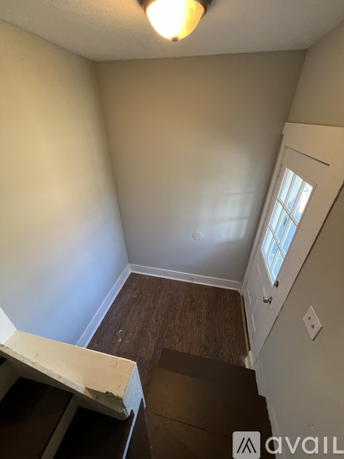 A room with a wooden floor and a window.