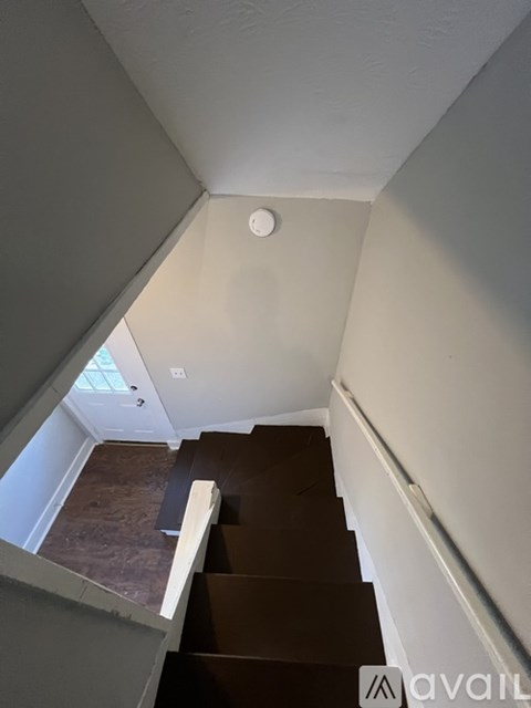 A staircase with a white railing and brown steps.