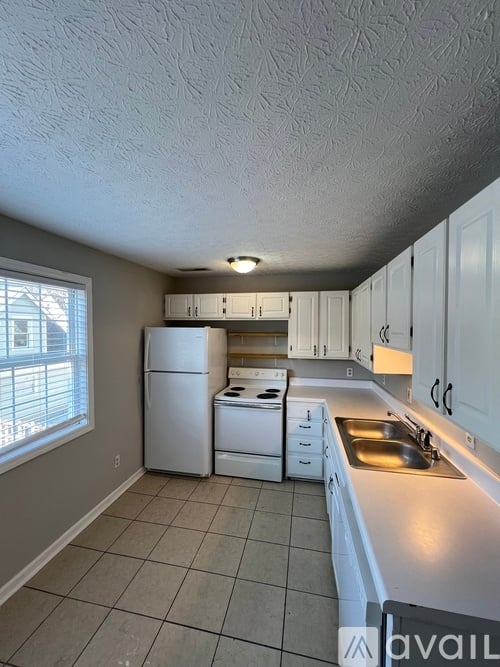 A kitchen with white appliances and cabinets.