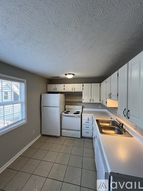 A kitchen with white appliances and cabinets.