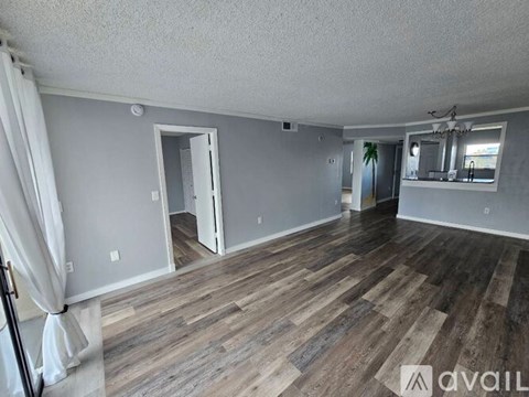A room with wooden flooring and a mirror on the wall.