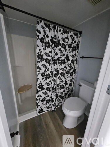 A small bathroom with a toilet and a shower curtain.