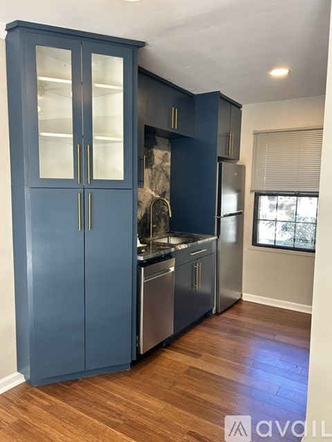 A kitchen with a blue cabinet and stainless steel appliances.