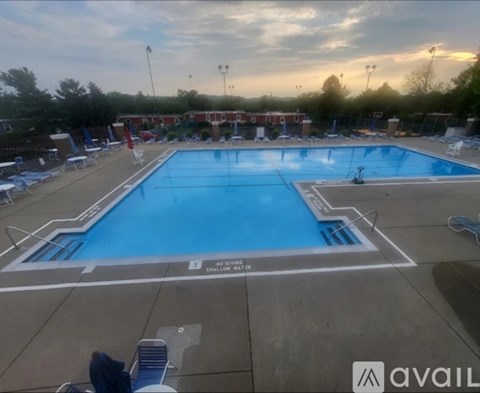 A large outdoor swimming pool with a no dive sign.