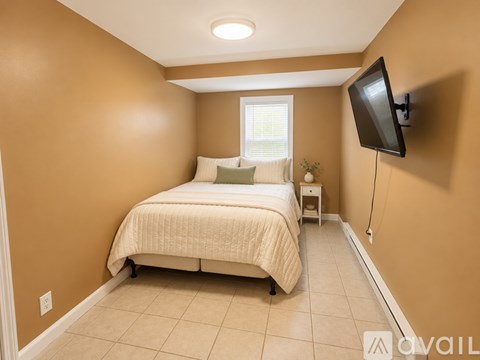 A bedroom with a bed, nightstand, and television.