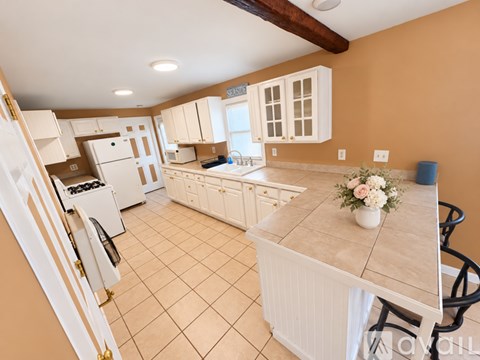 A kitchen with white appliances and cabinets.