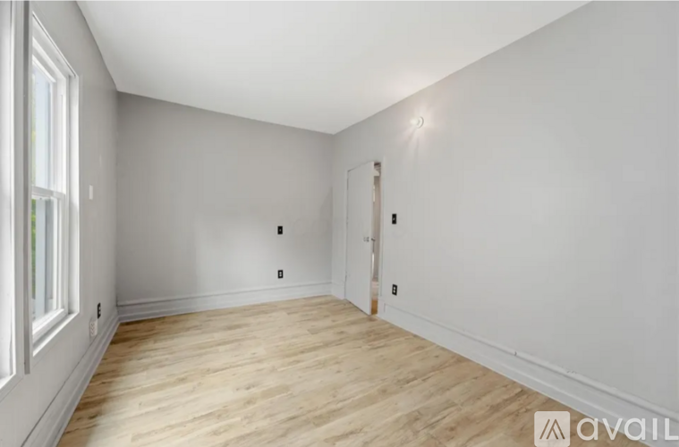 A room with wooden flooring and white walls.