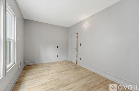 A room with wooden flooring and white walls.