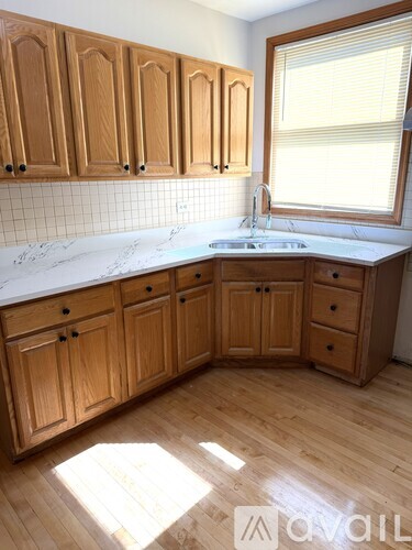 A kitchen with wooden cabinets and a white countertop.
