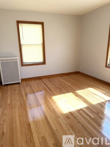 A room with wooden flooring and a window.