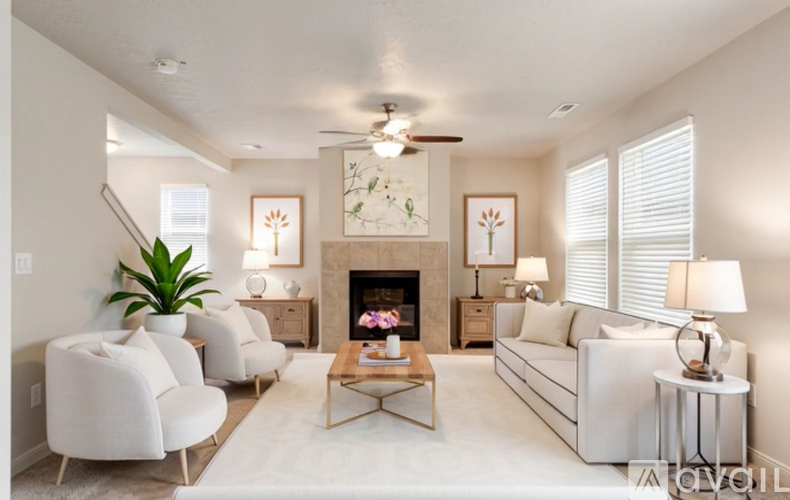 A living room with a fireplace and a ceiling fan.