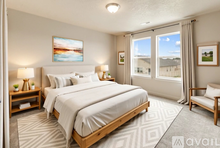 A well-lit bedroom with a large bed and a view of the outside through the window.