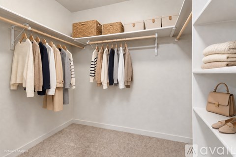 A white closet with clothes and a handbag on the shelf.