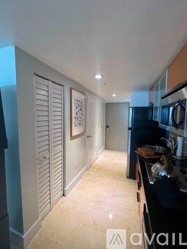 A kitchen with a black counter top and white cabinets.