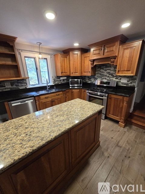 A kitchen with wooden cabinets and granite countertops.