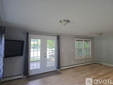 A living room with a television, sliding glass doors, and a window.