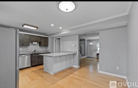 A kitchen with a refrigerator, sink, and countertop is shown.