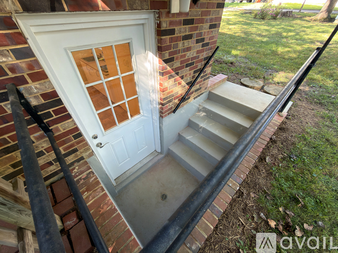 A white door with a glass window is on a brick wall.
