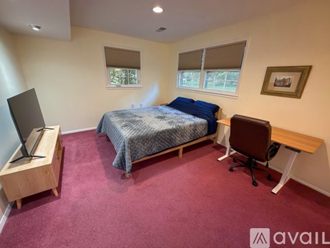 A bedroom with a bed, desk, and chair.