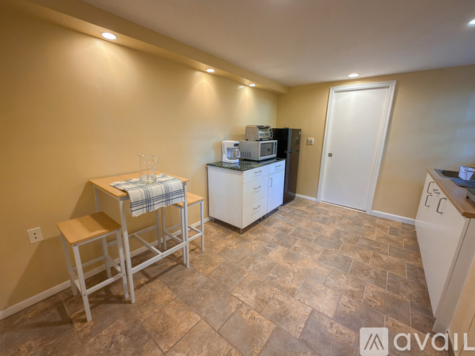 A kitchen with a refrigerator, microwave, and a table with a towel on it.