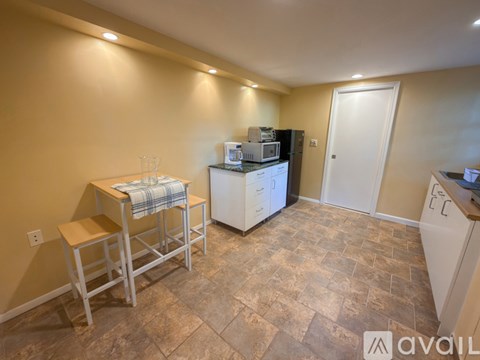 A kitchen with a refrigerator, microwave, and a table with a towel on it.