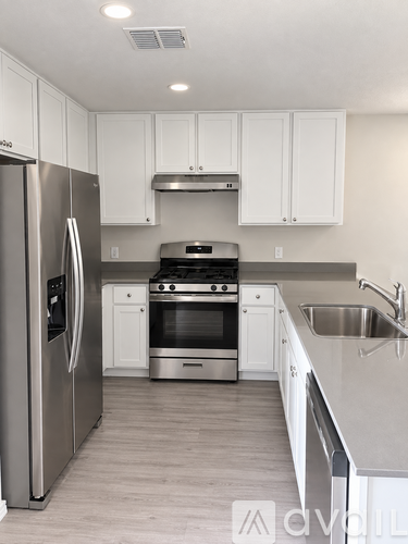 A modern kitchen with stainless steel appliances and white cabinets.