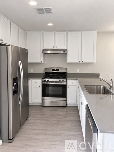 A modern kitchen with stainless steel appliances and white cabinets.