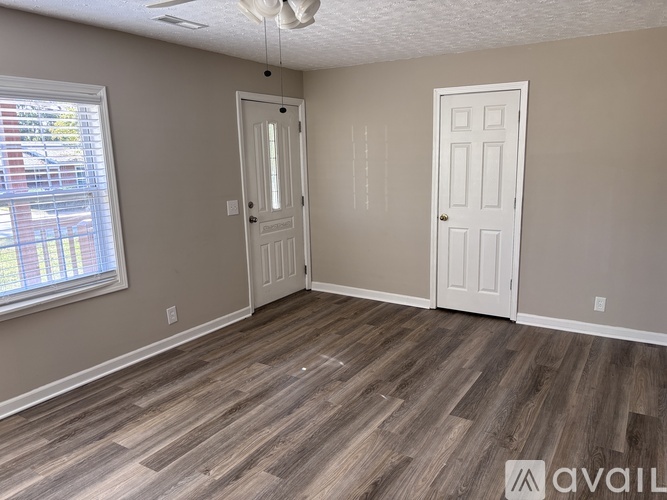 A room with wood flooring and two white doors.