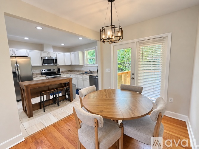 A kitchen with a table and chairs in front of a window.