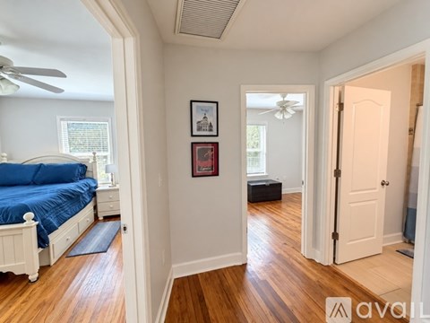 A bedroom with a blue bed and wooden floors.