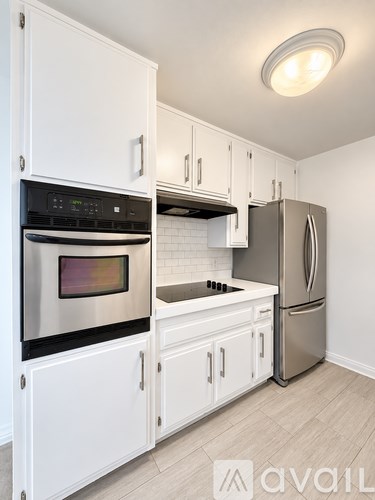 A kitchen with white cabinets and stainless steel appliances.