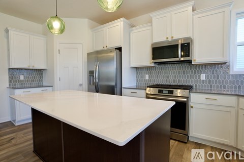 A kitchen with white cabinets and a large island.