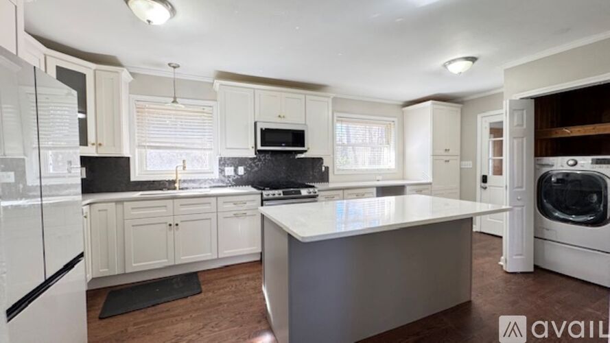 A kitchen with white cabinets and a black countertop.