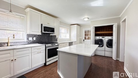 A kitchen with white cabinets and a black countertop.