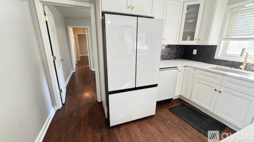 A kitchen with white appliances and cabinets.