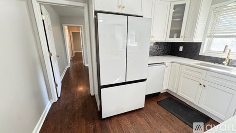 A kitchen with white appliances and cabinets.